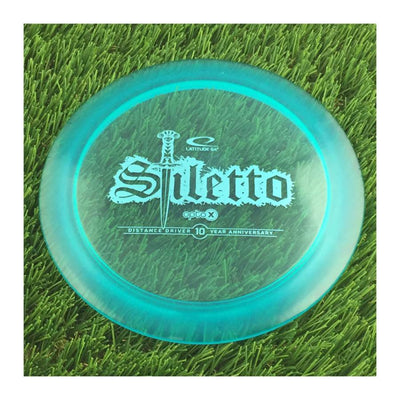 Latitude 64 Opto-X Stiletto with 10 Year Anniversary Sword Stamp - 173g - Translucent Blue